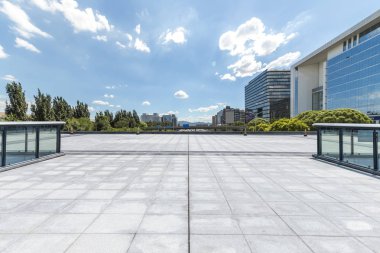 Panoramik siluet ve boş yolu, boş beton zemini olan modern iş binaları.
