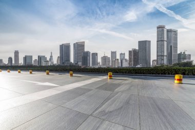 Panoramik siluet ve boş yolu, boş beton zemini olan modern iş binaları.