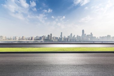 Panoramik siluet ve boş yolu, boş beton zemini olan modern iş binaları.