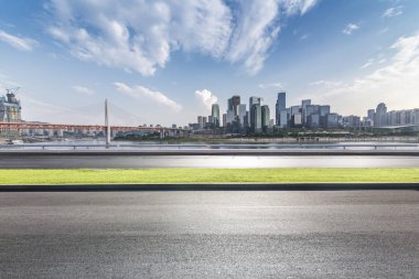 Panoramik siluet ve boş yolu, boş beton zemini olan modern iş binaları.