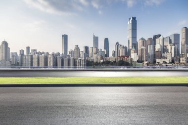 Panoramik siluet ve boş yolu, boş beton zemini olan modern iş binaları.