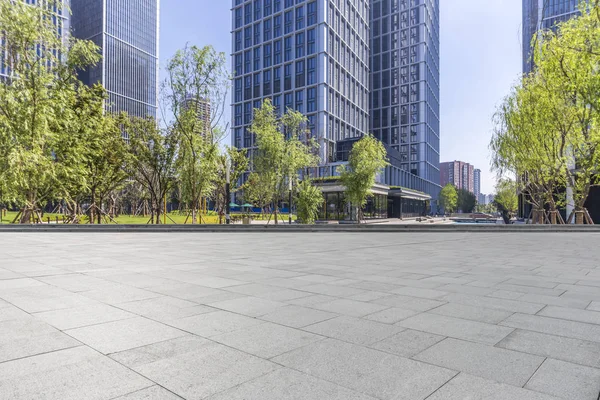 Panoramik siluet ve boş yolu, boş beton zemini olan modern iş binaları.