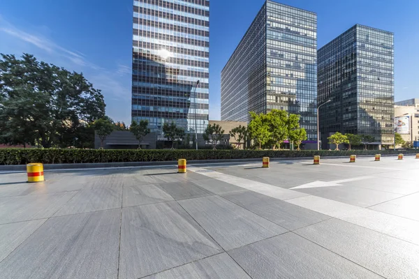 Panoramik siluet ve boş yolu, boş beton zemini olan modern iş binaları.