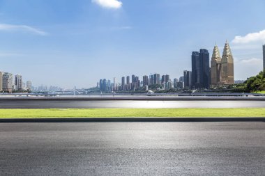 Panoramik siluet ve boş yolu, boş beton zemini olan modern iş binaları.