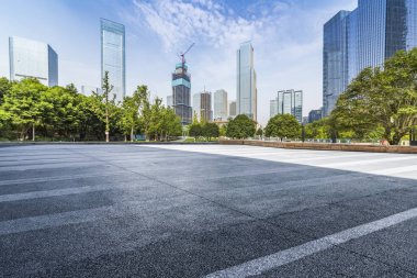 Panoramik siluet ve boş yolu, boş beton zemini olan modern iş binaları.
