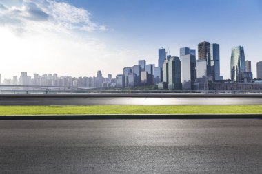 Panoramik siluet ve boş yolu, boş beton zemini olan modern iş binaları.