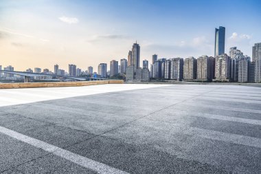 Panoramik siluet ve boş yolu, boş beton zemini olan modern iş binaları.