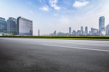 Panoramik siluet ve boş yolu, boş beton zemini olan modern iş binaları.