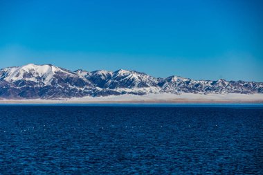 Kar dağ arka plan yılı, Çin Xinjiang, donmuş Sailimu Gölü