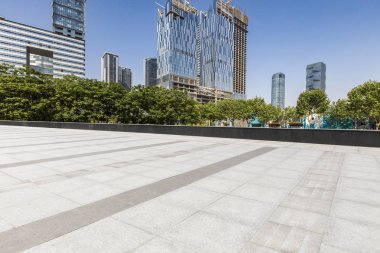 Panoramik siluet ve boş yolu, boş beton zemini olan modern iş binaları.