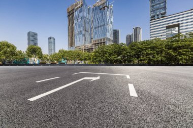 Panoramik siluet ve boş yolu, boş beton zemini olan modern iş binaları.