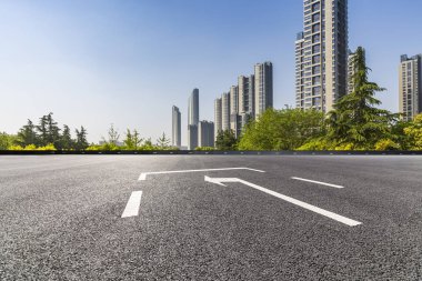 Panoramik siluet ve boş yolu, boş beton zemini olan modern iş binaları.
