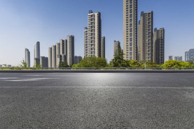 Panoramik siluet ve boş yolu, boş beton zemini olan modern iş binaları.