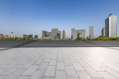 Panoramik siluet ve boş yolu, boş beton zemini olan modern iş binaları.