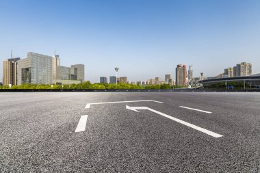 Panoramik siluet ve boş yolu, boş beton zemini olan modern iş binaları.