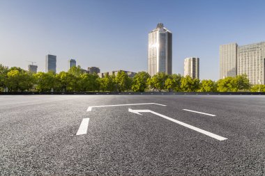 Panoramik siluet ve boş yolu, boş beton zemini olan modern iş binaları.