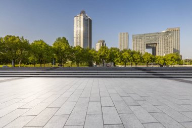Panoramik siluet ve boş yolu, boş beton zemini olan modern iş binaları.