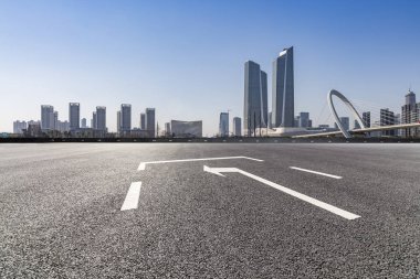 Panoramik siluet ve boş yolu, boş beton zemini olan modern iş binaları.