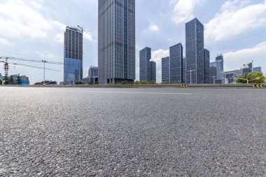 Panoramik siluet ve boş yolu, boş beton zemini olan modern iş binaları.