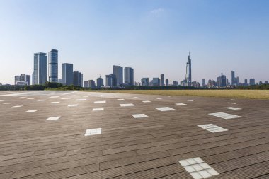 Panoramik siluet ve boş yolu, boş beton zemini olan modern iş binaları.