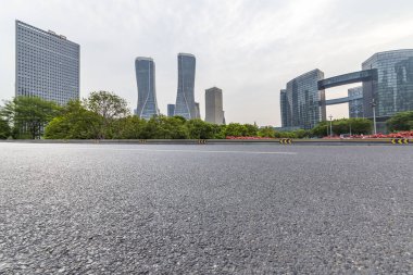 Panoramik siluet ve boş yolu, boş beton zemini olan modern iş binaları.