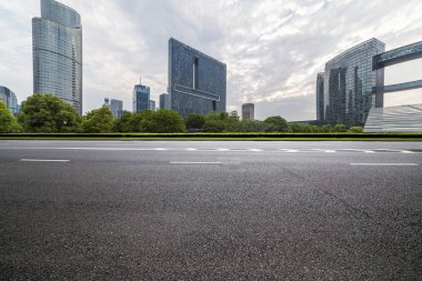 Panoramik siluet ve boş yolu, boş beton zemini olan modern iş binaları.