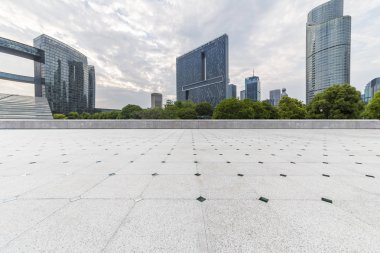 Panoramik siluet ve boş yolu, boş beton zemini olan modern iş binaları.