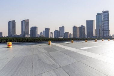 Panoramik siluet ve boş yolu, boş beton zemini olan modern iş binaları.