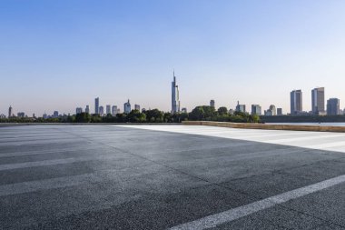 Panoramik siluet ve boş yolu, boş beton zemini olan modern iş binaları.