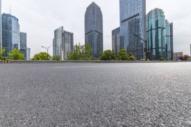 Panoramik siluet ve boş yolu, boş beton zemini olan modern iş binaları.