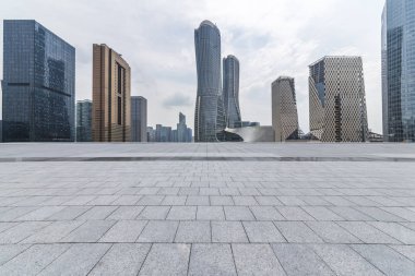 Panoramik siluet ve boş yolu, boş beton zemini olan modern iş binaları.