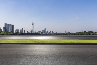 Panoramik siluet ve boş yolu, boş beton zemini olan modern iş binaları.