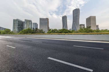 Panoramik siluet ve boş yolu, boş beton zemini olan modern iş binaları.