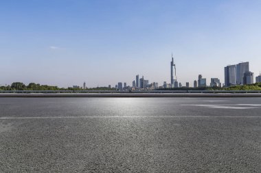 Panoramik siluet ve boş yolu, boş beton zemini olan modern iş binaları.
