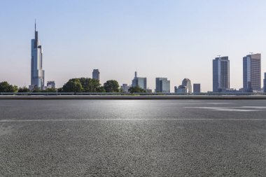 Panoramik siluet ve boş yolu, boş beton zemini olan modern iş binaları.