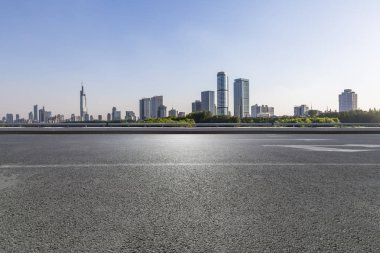 Panoramik siluet ve boş yolu, boş beton zemini olan modern iş binaları.