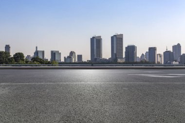 Panoramik siluet ve boş yolu, boş beton zemini olan modern iş binaları.