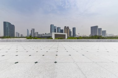 Panoramik siluet ve boş yolu, boş beton zemini olan modern iş binaları.