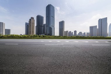 Panoramik siluet ve boş yolu, boş beton zemini olan modern iş binaları.