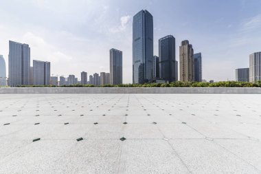 Panoramik siluet ve boş yolu, boş beton zemini olan modern iş binaları.