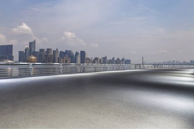 Panoramik siluet ve boş yolu, boş beton zemini olan modern iş binaları.