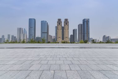 Panoramik siluet ve boş yolu, boş beton zemini olan modern iş binaları.