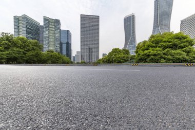Panoramik siluet ve boş yolu, boş beton zemini olan modern iş binaları.