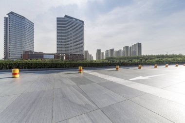 Panoramik siluet ve boş yolu, boş beton zemini olan modern iş binaları.