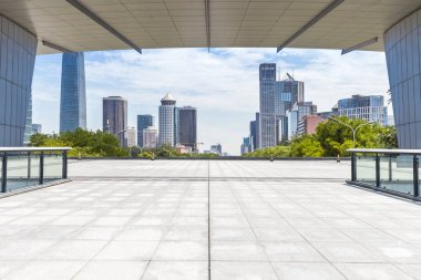 Panoramik siluet ve boş yolu, boş beton zemini olan modern iş binaları.