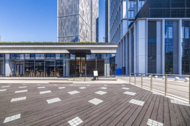 Panoramik siluet ve boş yolu, boş beton zemini olan modern iş binaları.