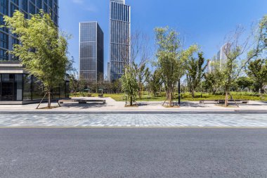 Panoramik siluet ve boş yolu, boş beton zemini olan modern iş binaları.
