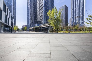Panoramik siluet ve boş yolu, boş beton zemini olan modern iş binaları.