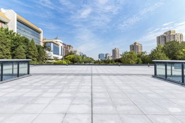 Panoramik siluet ve boş yolu, boş beton zemini olan modern iş binaları.