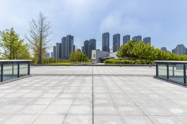 Panoramik siluet ve boş yolu, boş beton zemini olan modern iş binaları.